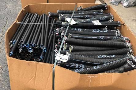 Large boxes filled with black replacement garage door springs in Beacon Hill