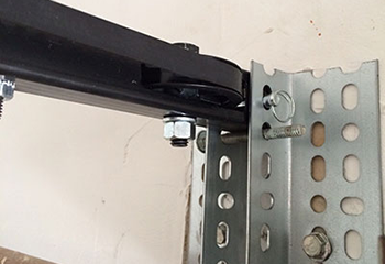 Vertical garage door track and cable assembly installed inside Bellevue home garage.
