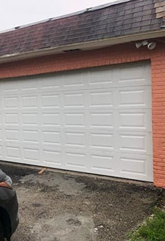 Exterior of a Seattle home with new double white garage doors installed