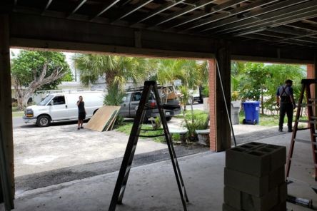 Interior view of open garage in Seattle with ladders and crew working on garage door installation