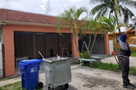 Technicians preparing a garage in Seattle for new door installation, old doors removed, and site cleared