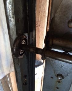 Damaged garage door roller and track before repair in Puyallup WA home