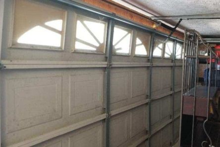 Damaged garage door roller and track before repair in Puyallup WA home