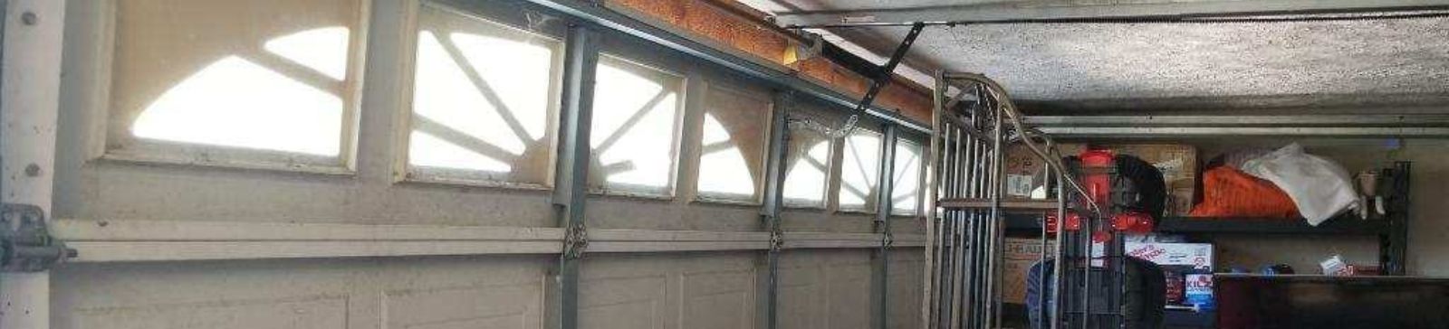 Damaged garage door roller and track before repair in Puyallup WA home