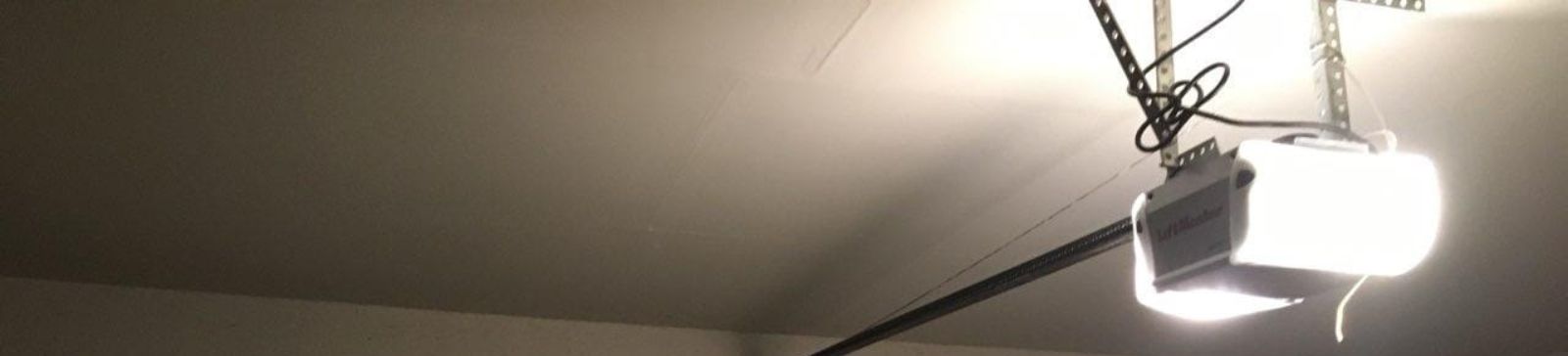 Garage Interior with Automatic Door Opener – Bellevue Wide angle of Bellevue garage with closed automatic door and LiftMaster opener on ceiling