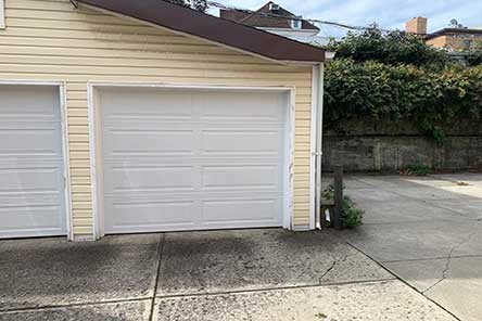 Driveway and close-up of a new single white garage door on Mercer Island home