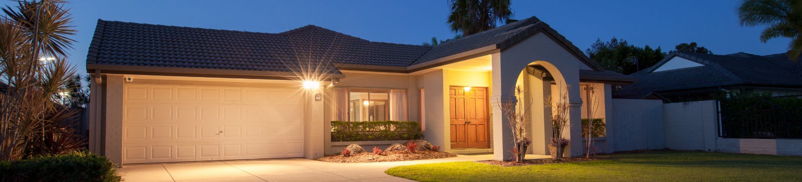 Front view of a suburban Seattle home with a closed garage door lit up at night