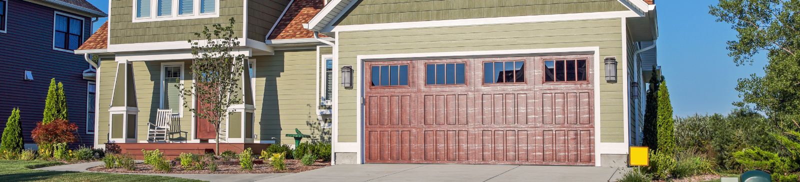 Front view of a modern home with a newly installed garage door, representing professional garage door repair and installation services in Lakewood, WA