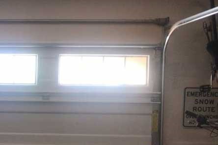 Close-up of a garage door corner moving along a curved track in Seattle