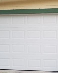 Garage technician installing a new white sectional garage door in Everett, WA.