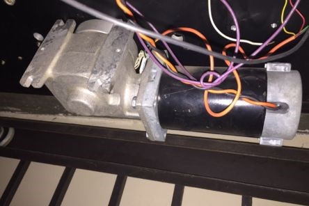 Close-up of a garage door opener motor with wires exposed during Renton garage door repair
