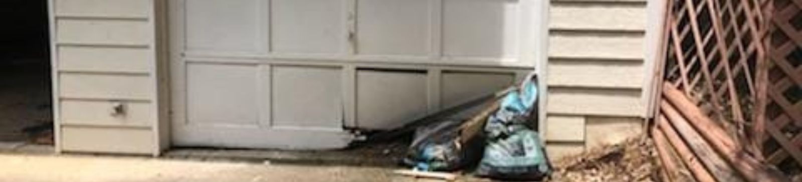 Garage with Damaged Door Panel Awaiting Repair – Newcastle Wide view of a Newcastle garage with a visibly damaged garage door panel in need of same day replacement