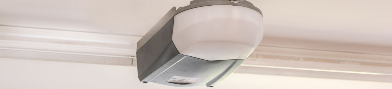 Close-up of a modern garage door opener installed on the ceiling, illustrating the benefits of upgrading to a new garage door opener for improved safety and performance.