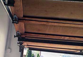 Detailed view of garage door roller bracket attached to wood panel in White Center